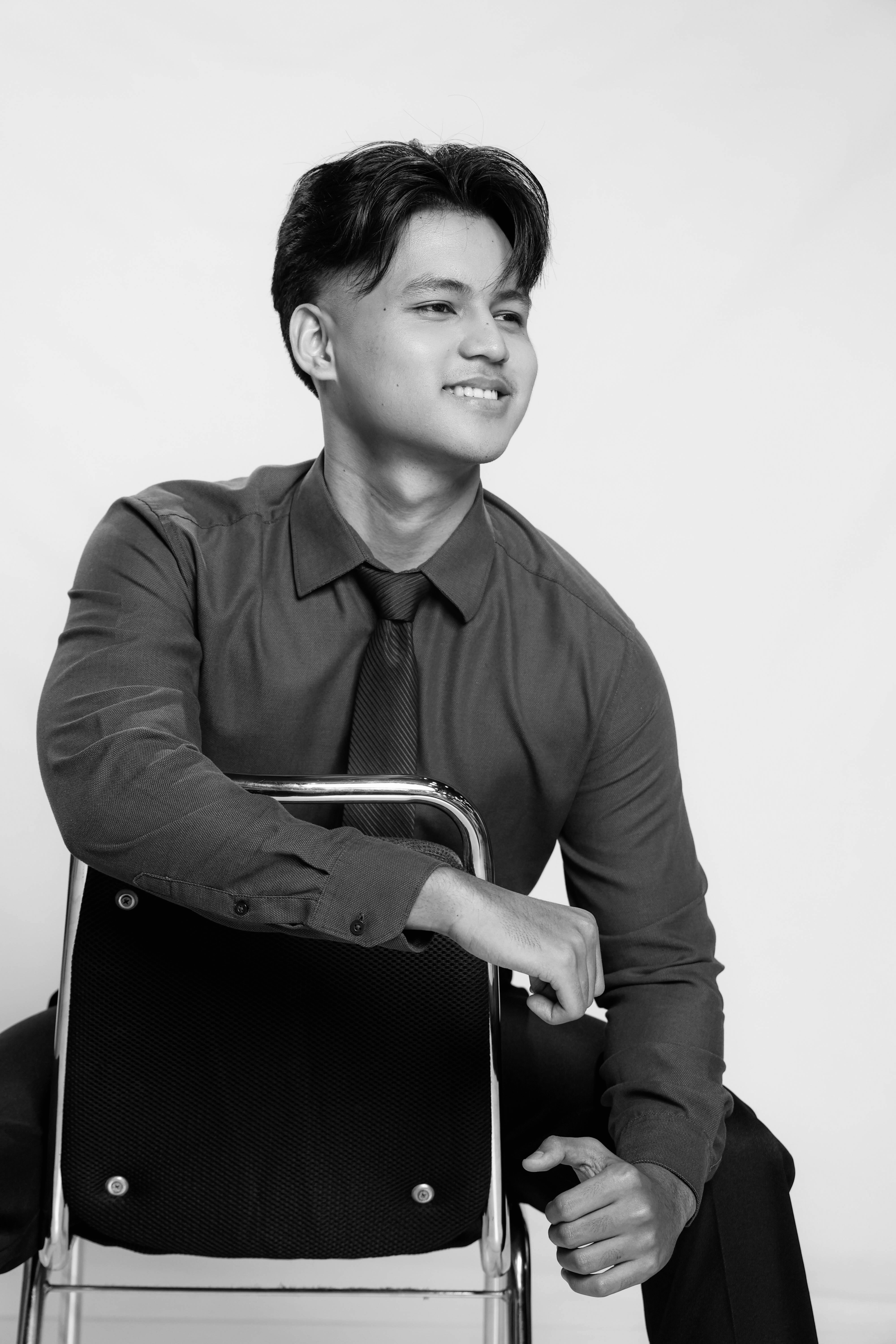 Portrait of Angelo Miranda seated in a studio.